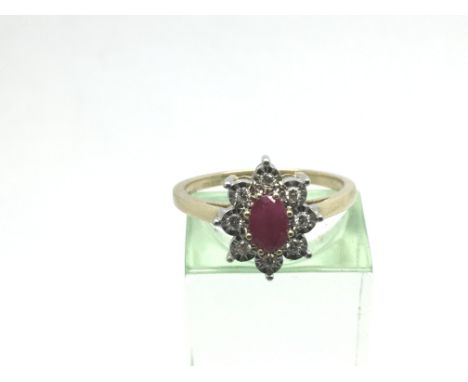 A 9ct gold oval ruby and diamond cluster ring in the form of a flowerhead. Ruby approx 0.57ct, diamonds approx 0.10ct, approx