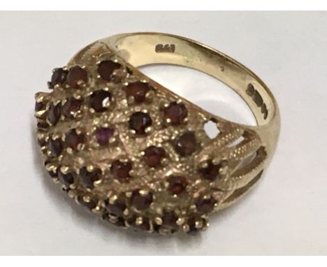 A yellow gold ring with garnet set in dome shape. Ring size M