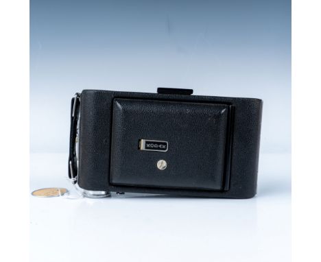 A classic folding camera from the mid-20th century. This model features a durable metal body with a leatherette covering, a f