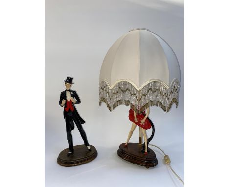 Two vintage figural ornaments of a dancing gentleman and lady, one in the form of a lamp with shade, the largest is 76cm H