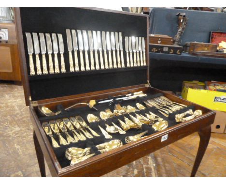 Gilded silver plate Kings pattern canteen of cutlery in leather inset mahogany table 