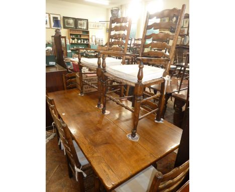 Furley's oak coffin style dining table with single drop leaf and 8 rush-seated ladder-back chairs 