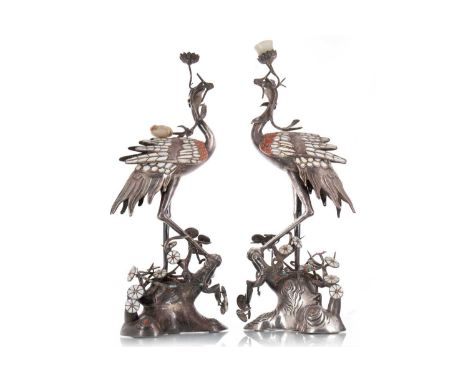 PAIR OF SINO-TIBETAN WHITE METAL CRANE CANDLESTICKS CIRCA LATE 19TH / EARLY 20TH CENTURY test for silver, inset with mother o