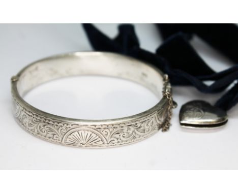 A hallmarked silver bangle and a heart shaped locket marked 'Solid Silver'.  