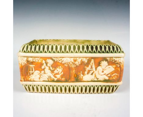 A rectangular planter with creamed colored Corinthians and cherubs set against brown ground. Artist: Frederick RheadIssued: c