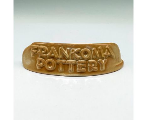 Curved, raised design on display sign is colored in light brown. Sign has flat bottom to stand independently. Issued: 20th ce