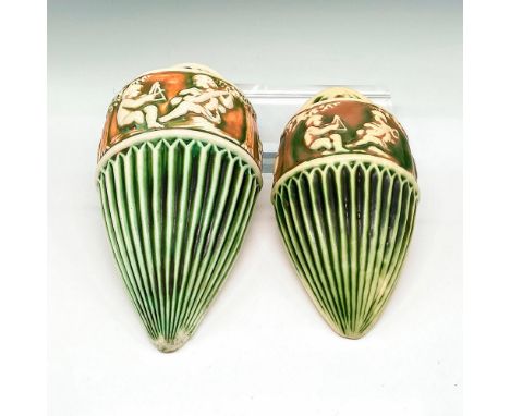 Conical, ribbed pottery finished with light glaze over green and rust coloration. Banded design of seated cherubs playing ins