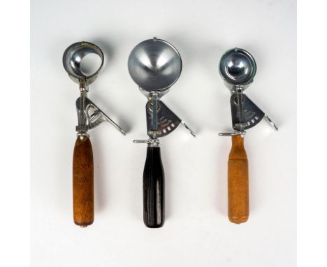 This fantastic vintage ice cream scoop grouping includes 2 wood handled and one early black plastic handled scoops with stain
