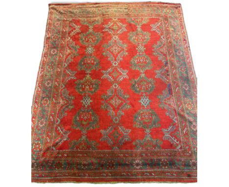 A large Turkish carpet, with triple row of stylised medallions on a red ground, multi bordered, 413 x 345cm. Condition - fair