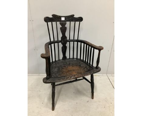 A 19th century Windsor comb back elbow chair, later stained and carved, width 69cm, depth 45cm, height 101cm. Condition - fai
