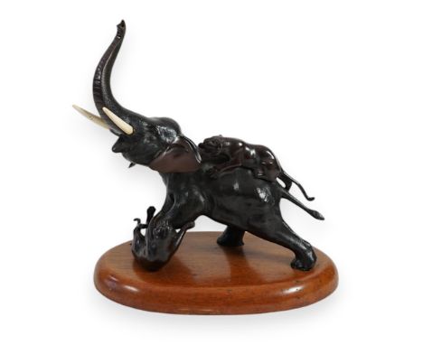 A Japanese patinated bronze group of two tigers attacking an elephant, Meiji period, the elephant roaring with raised trunk, 
