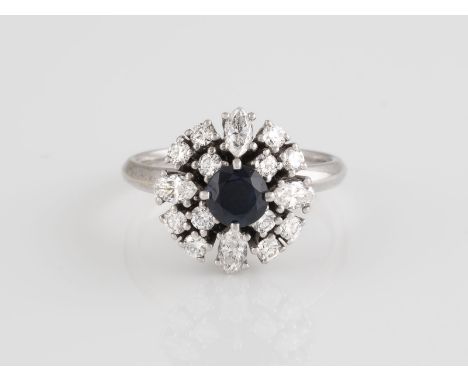 RING Weißgold. Ringmaß ca. 54,5, Ges.-Gew. ca. 6,3 g. Schiene geprüft 18 K. Ein rund facettierter Saphir, ca. 0,70 ct., 16 Di