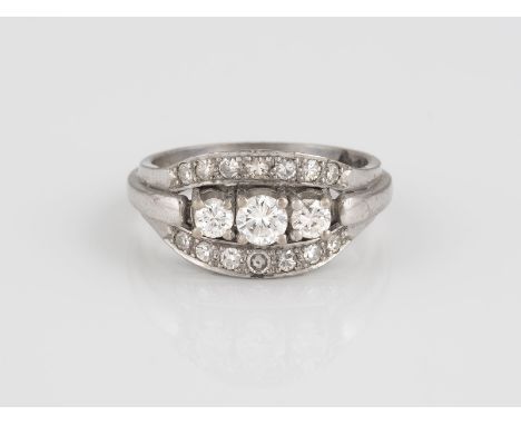 RING Weißgold. Ringmaß ca. 57, Ges.-Gew. ca. 7,7 g. Gest. 585. Drei Brilanten, zusammen ca. 0,54 ct., 14 Diamanten im 8/8-Sch