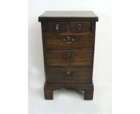 A  Desk:
George III mahogany single pedestal desk, the hinged top opening into a desk top, above two over three drawer arrang