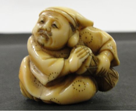 A Japanese Ivory Netsuke:
Edo period
In the shape of a seated drummer. Signed Mitsutomo to the base.
H 3 cm  CONDITION REPORT