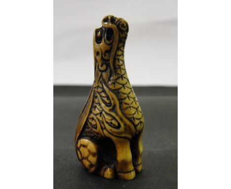 A Japanese Ivory Netsuke:
19th century
In the shape of a kirin, the head turned upwards and scaly body with curling flames. S