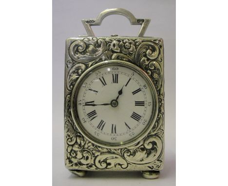 A 19th Century Silver Carriage Clock:
with full silver case embossed with floral scrolls on ball feet.  Vacant circular carto