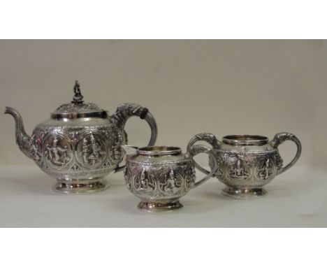 A 19th Century Silver Anglo-Indian Three-Piece Tea Set:
the teapot with elephant handle and spout and embossed deities to bod