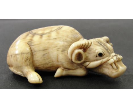 A Japanese Ivory Netsuke:
Edo period
In the shape of a recumbent ox, the head tied with a rope. Signed Tomotada to the base.
