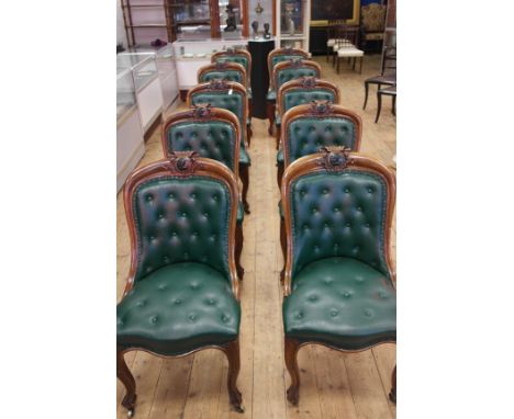 A set of ten dining chairs:
19th century oak
 leather buttonback chairs, the central upper rail with an ebony side portrait o