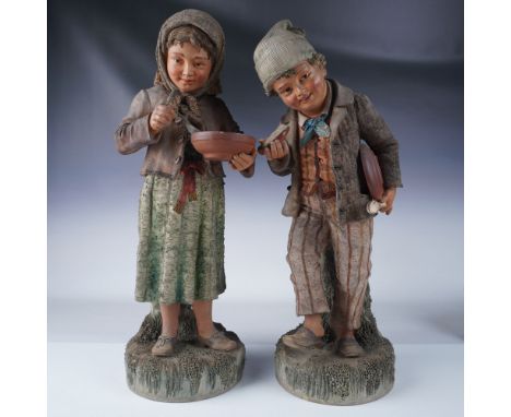 These delightful ceramic figurines portrays a young boy and girl dressed in period attire, capturing a moment of youthful inn