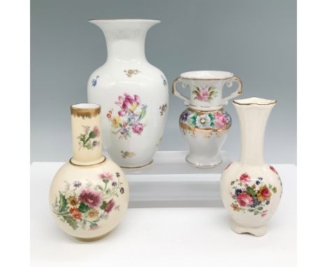 A collection of four porcelain vases featuring intricate floral motifs and gilded accents. This set includes a Reichenbach fi