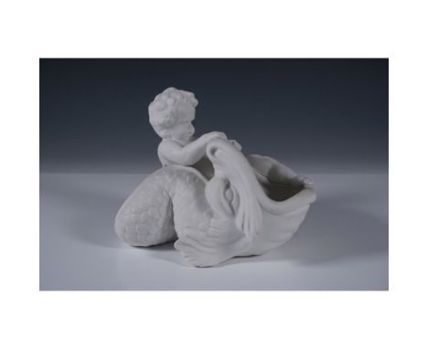 Elegant bisque porcelain vase featuring a cherub riding a stylized sea creature. This unglazed matte white piece showcases in