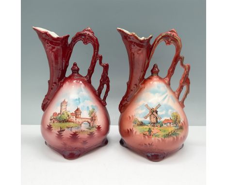 Pair of vintage hand-painted pottery pitchers, each standing 7.25"H. These pitchers feature scenic motifs, with one depicting