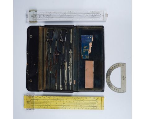 This lot includes two vintage Keuffel &amp; Esser slide rules, one yellow and one white, along with a drafting tool set store