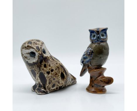 A pair of intricately crafted ceramic owl figurines. Each features detailed texturing and vibrant glazing, with one owl perch