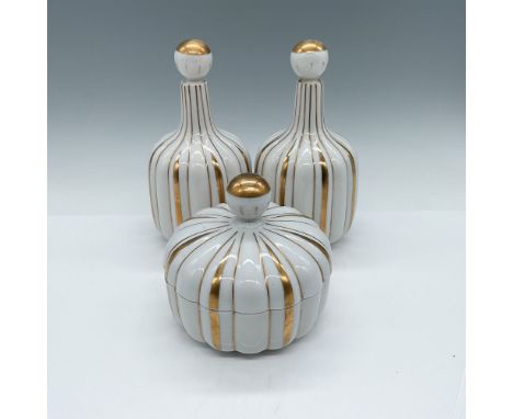 A set of three matching Irice ceramic pieces featuring elegant gilded gold accents on white. Includes two bottles with stoppe