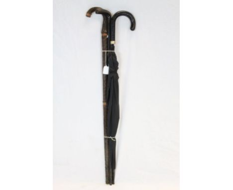 Two vintage walking sticks and a similar umbrella 