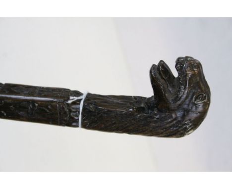 Antique walking stick of square form profusely carved to stem with stylized Lion Head handle