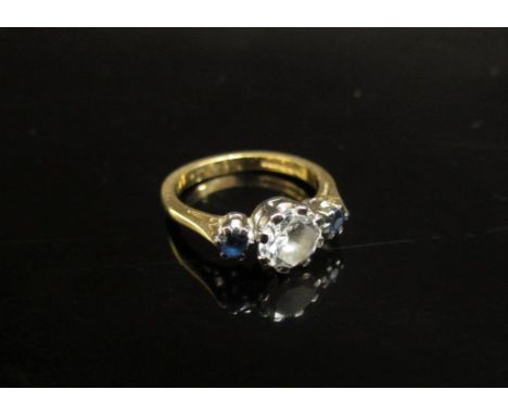 An 18ct gold ring centrally set with a clear stone flanked by sapphires. Size K/L, 3.8g 