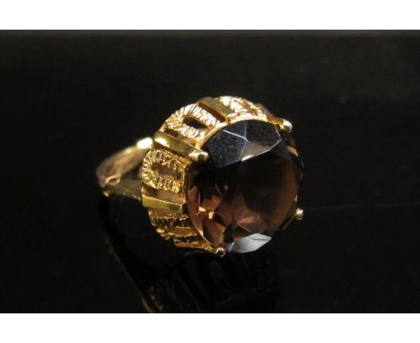 A gold ring set with a circular smoky quartz in high mount. Size M, 4.8g 