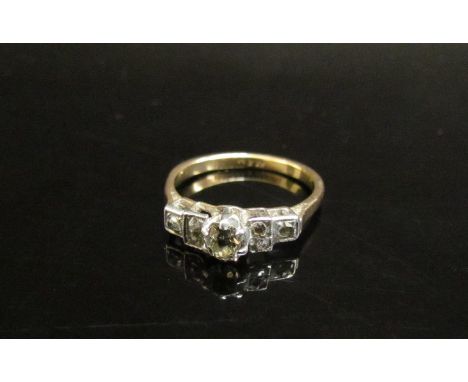 An 18ct gold ring the central diamond 0.25ct approx flanked by three old cut diamonds. Size K, 2.4g 
