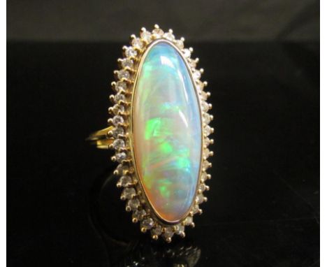 An opal and diamond ring the central oval opal 26.9mm x 10.4mm x 5.4mm, estimated weight 8.87ct framed by forty round brillia