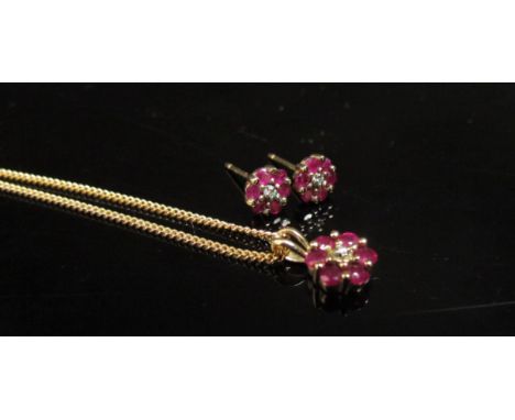 A 9ct gold neckchain 46cm long hung with a ruby and diamond daisy pendant, with matching earrings (no backs) 3.4g 