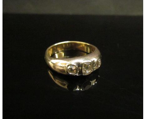 An unmarked gold ring set with three old cut diamonds in a rubover setting, 0.60ct total approx. Size M, 5.1g 