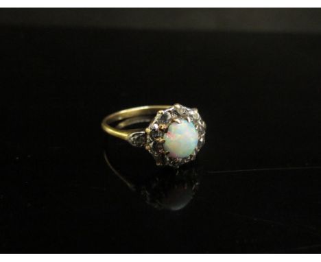 A gold platinum set opal and diamond cluster ring. Size Q, 3.6g 