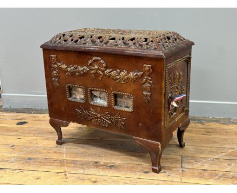 A late 19thc French cast iron enamelled Mirus stove with pierced caddy top and floral and ribbon motif to front, with three s