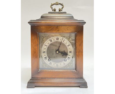 A Garrard mantle clock with Roman numeral chapter ring and baroque style loop handle, the movement typically finished with pe