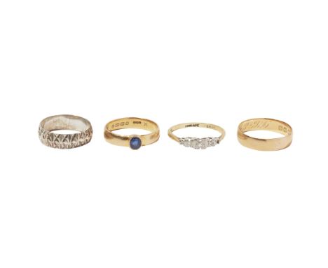 A collection of four ringsto include an 18ct gold band, set with an oval cut blue sapphire; a three stone diamond set ring, t