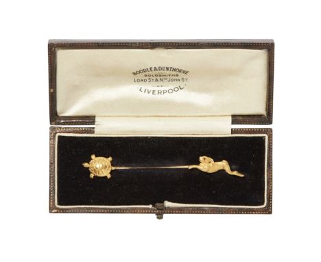 A novelty tortoise and hare stick pinapplied to each terminal with a tortoise and a hare, the hare set with a ruby eye, stamp