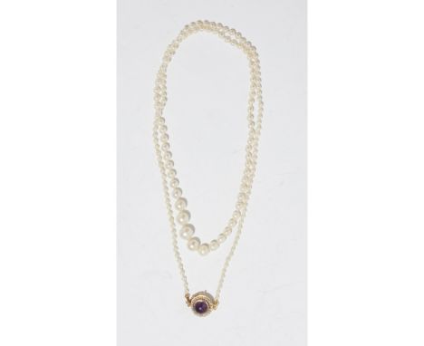 A pearl and amethyst set necklacecomposed of a row of graduated cultured pearls, the clasp set with an amethyst cabochon in a