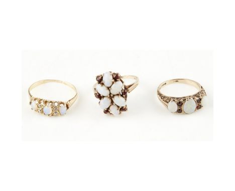 A collection of opal ringsto include an opal and diamond set ring, unmarked; a 9ct gold opal and garnet set ring, to a plain 