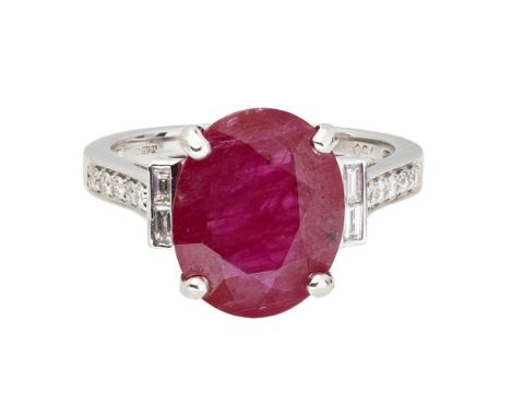 A ruby and diamond set ringclaw set with an oval cut ruby, flanked to either side by two baguette diamonds, the shoulders set