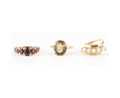 Three gem set ringsto include a 9ct gold citrine set cocktail ring; a five stone garnet set ring, stamped 375; and a five sto