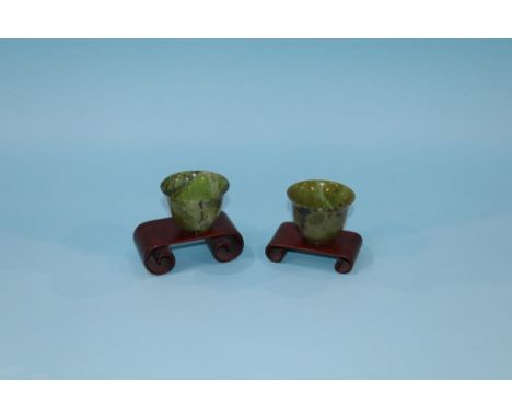 A pair of spinach coloured jade tea bowls, 4.5cm height approx.