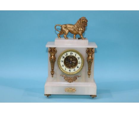An alabaster mantel clock, surmounted by a lion, 37cm height